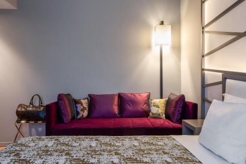 a living room with a red couch next to a bed at Fortyfive Squared Hotel in Rome