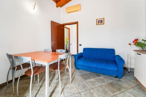 a dining room with a table and a blue couch at Residence Sulcis 2 in Masainas