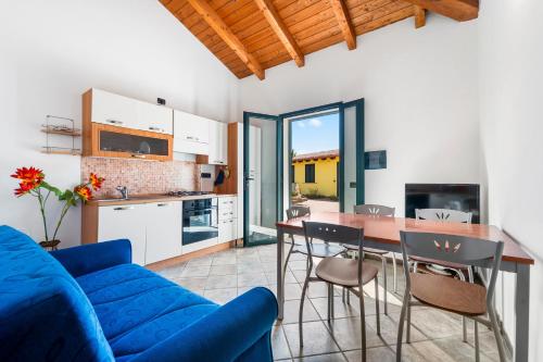 a living room with a blue couch and a kitchen at Residence Sulcis 2 in Masainas