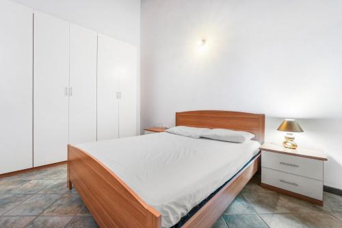 a bedroom with a bed and a night stand with a lamp at Residence Sulcis 2 in Masainas