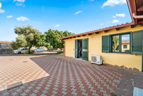 a house with a brick driveway next to a building at Residence Sulcis 2 in Masainas