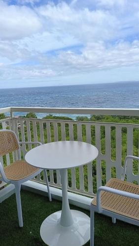 a white table and chairs on a balcony with the ocean at Royal Oceancrest Panglao Seaview in Dauis