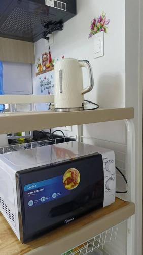a microwave sitting on a shelf in a kitchen at Royal Oceancrest Panglao Seaview in Dauis
