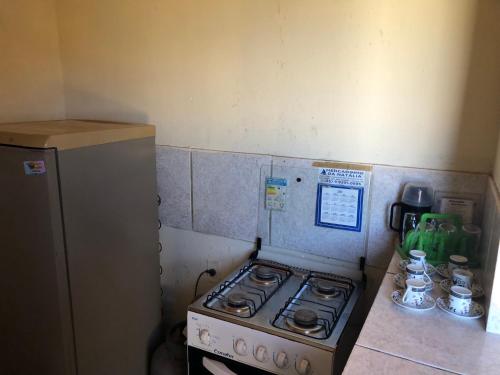 a small kitchen with a stove and a refrigerator at Aconchego Balbino 2 in Cascavel