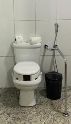 a white toilet in a bathroom with a trash can at Cassino All Inclusive Resort Poços de Caldas By Nacional Inn in Poços de Caldas