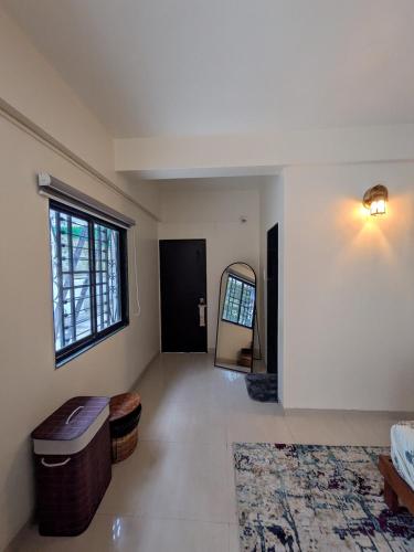 a living room with a large window and a mirror at Sanctuary by Nagarik Commune in Pune