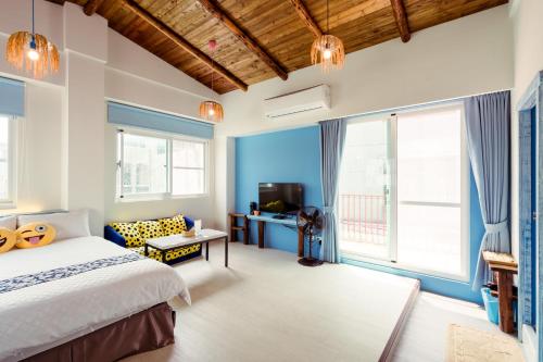 a bedroom with a large bed and a tv at 安平156民宿 in Tainan