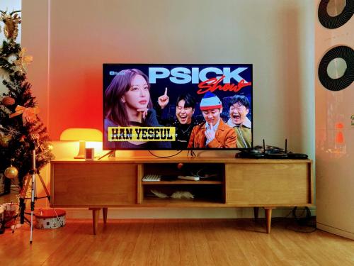 a flat screen tv sitting on top of a entertainment center at A spacious, cosy, independent house in Pohang