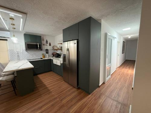 a kitchen with green cabinets and a stainless steel refrigerator at Villa Catalina Beach House in Punta Santiago