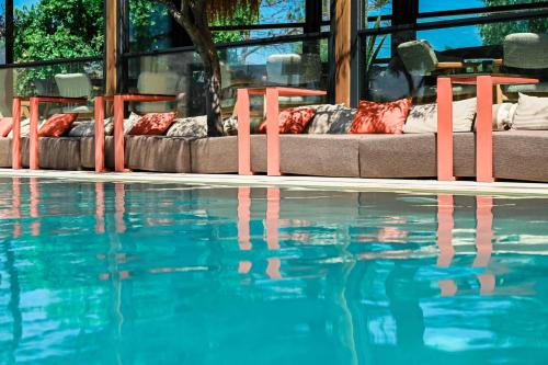 a pool of water with two beds next to it at Ikaros Suites in Amoudara Herakliou