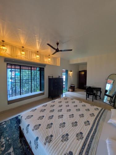 a bedroom with a large bed with a ceiling fan at Sanctuary by Nagarik Commune in Pune