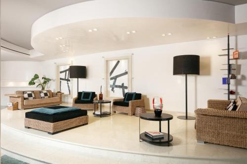 a living room with couches and chairs and a table at Hotel Mariver in Lido di Jesolo