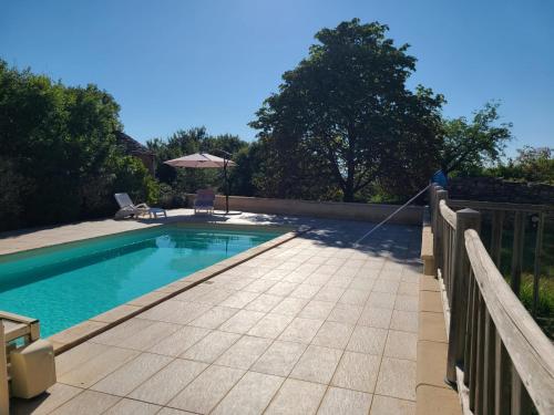 une piscine avec un tuyau fixé à une clôture dans l'établissement Charmant gîte en pierres, à Saint-Jean-de Laurs
