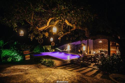 a backyard with a pool at night with lights at Recanto do Villa 1 in Trancoso