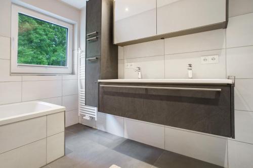 a white bathroom with a sink and a window at Ostseeperle in Boltenhagen