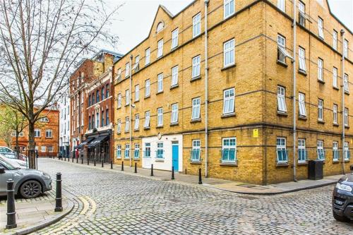 a large brick building on a cobblestone street at Alexander Fleming House, London in London