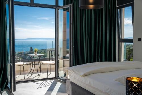 a bedroom with a bed and a balcony with a table at Villa Stone house in Novalja