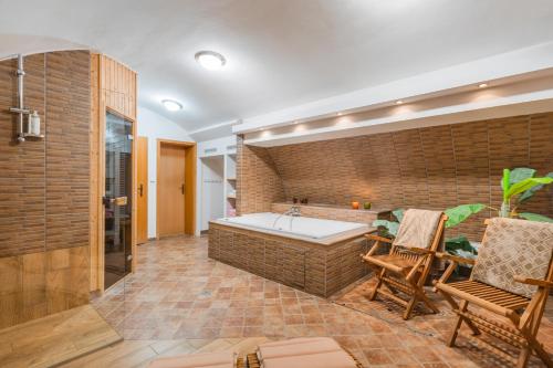 a large bathroom with a tub and a table and chairs at Hotel U Zlatého kohouta in Kroměříž