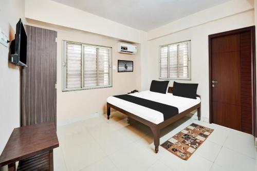 ダンバードにあるHotel O NINETEEN DEGREE Dhanbad Bus Standのベッドとテレビと窓のある寝室
