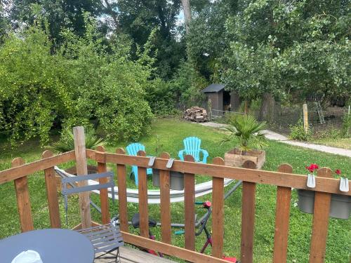a deck with chairs and a bird on the grass at La Cabane du Halage in Aire-sur-la-Lys