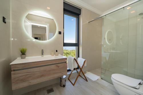 a bathroom with a sink and a shower with a mirror at Villa Stone house in Novalja