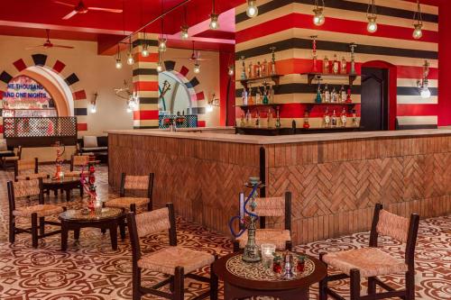 a bar at a restaurant with tables and chairs at JAZ Makadi Saraya Resort in Hurghada