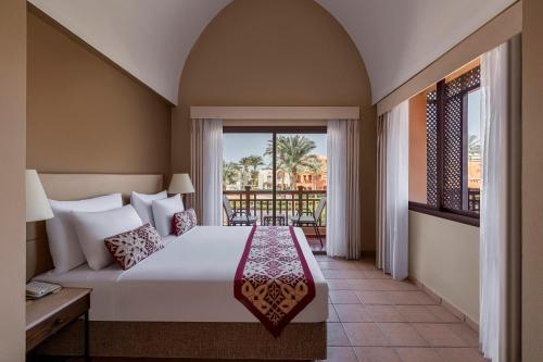 a hotel room with a bed and a balcony at JAZ Makadi Saraya Resort in Hurghada