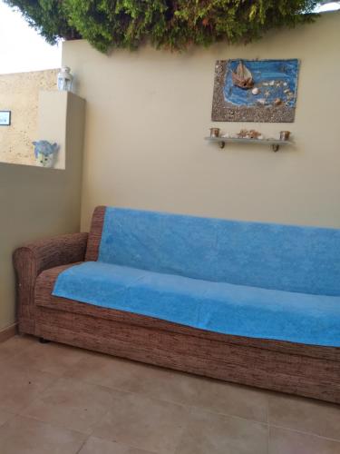 a couch with a blue cushion sitting against a wall at DREAMY SOUTH in Frangokastello