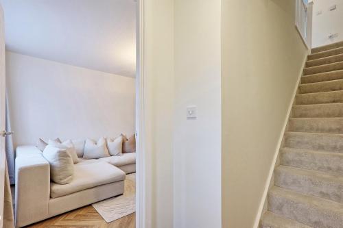 a living room with a white couch and stairs at Luxury and cosy 2 bed entire house in Essex 20 mins from beach in Colchester