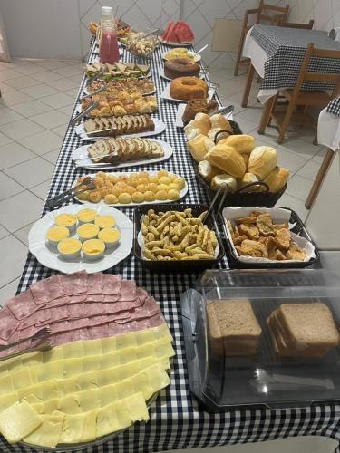 a table full of different types of cheese and bread at Hotel Águia in Teixeira de Freitas
