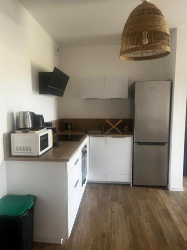 a small kitchen with a microwave and a refrigerator at Résidence Petra Paolina in Folelli