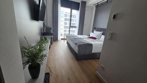a bedroom with a bed and a large window at Frames Hotel GmbH in Mülheim-Kärlich