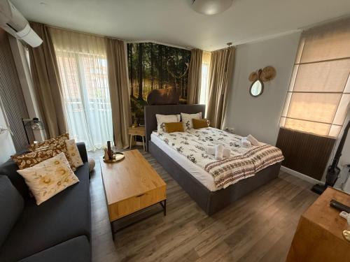 Un dormitorio con una cama, un sofá y una mesa. en Luxury Studio1 in Hotel Friends SPA, en Bansko