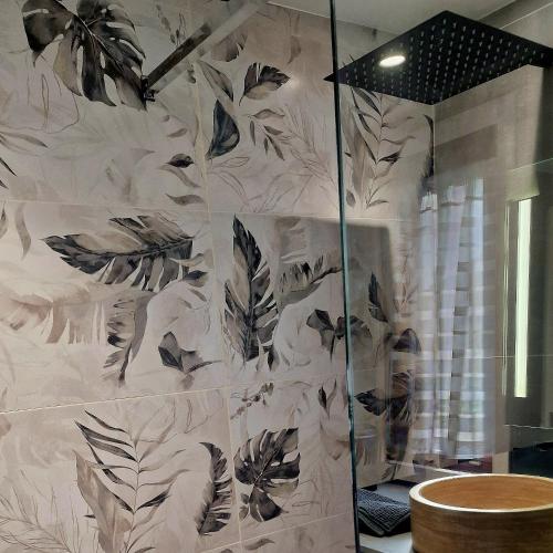 La salle de bains est pourvue d'une douche et de papier peint noir et blanc. dans l'établissement Villa pour 5 personnes avec jardin et piscine privée, à Villeneuve-Loubet