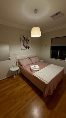 a bedroom with a large bed with a pink blanket at 2 Bdrm Walkerville Apartment - Spacious, ducted heating & cooling, centerally located! in North Adelaide