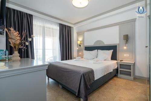 a hotel room with a large bed and a window at Daria Boutique Hotel in Eforie Sud