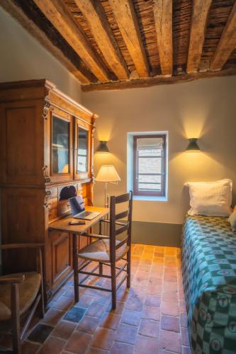 a bedroom with a desk and a bed and a deskicterictericterswersswers at Le Domaine de Richebourg - Pierres d'Histoire in Richebourg
