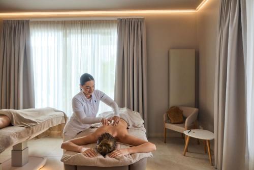 a woman is sitting on a bed with a person at ROBINSON Fleesensee in Göhren-Lebbin