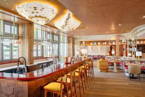 a restaurant with a bar with chairs and tables at La Résidence - Thalazur Arcachon in Arcachon