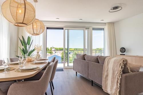a dining room with a table and a couch at Appartement Havenzicht 13A Kortgene in Kortgene