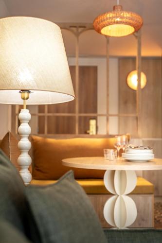 a table with a white lamp and a table with plates at La Résidence - Thalazur Arcachon in Arcachon
