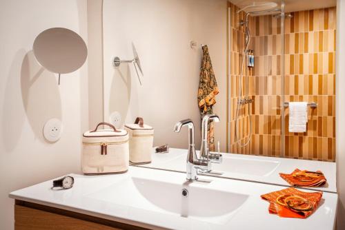a bathroom with a sink and a shower at La Résidence - Thalazur Arcachon in Arcachon