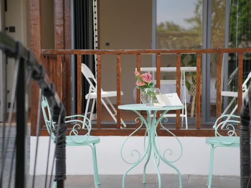 a table with a vase of flowers on a porch at Huangshan Hongcun Weizhashan Xunxi Hotel in Huangshan