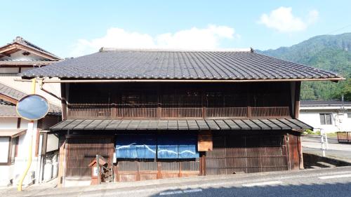 a building with a black roof on a street at Kashiwaya Inn in Nagiso