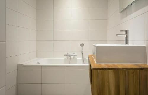 Baño blanco con lavabo y bañera en G-15 Bouwlust, en De Cocksdorp