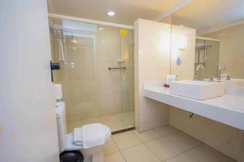 a bathroom with a sink and a shower and a toilet at Maceió Atlantic Suites in Maceió
