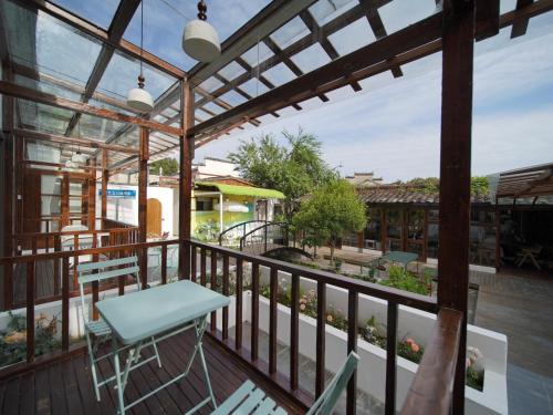 a patio with a table and chairs on a deck at Huangshan Hongcun Weizhashan Xunxi Hotel in Huangshan