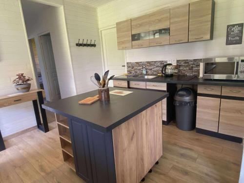 a kitchen with a island in the middle of it at Maison en bois Baie de Somme in Saint-Blimont
