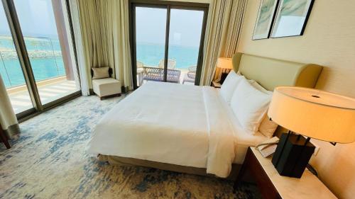 a hotel room with a bed and a view of the ocean at شقه فاخره في فندق العنوان ثلاث غرف نوم اطلاله علي البحر مباشره in Fujairah