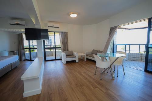 a living room with a bed and a table with chairs at Maceió Atlantic Suites in Maceió